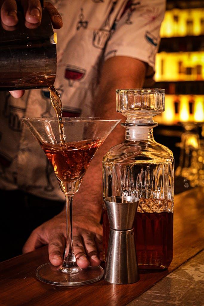 Bartender skillfully pouring a classic cocktail in a stylish bar atmosphere.
